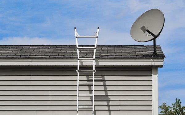 Ladder next to satellite dish on roof
