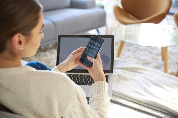 Woman on couch using a mobile app for external TV tuner