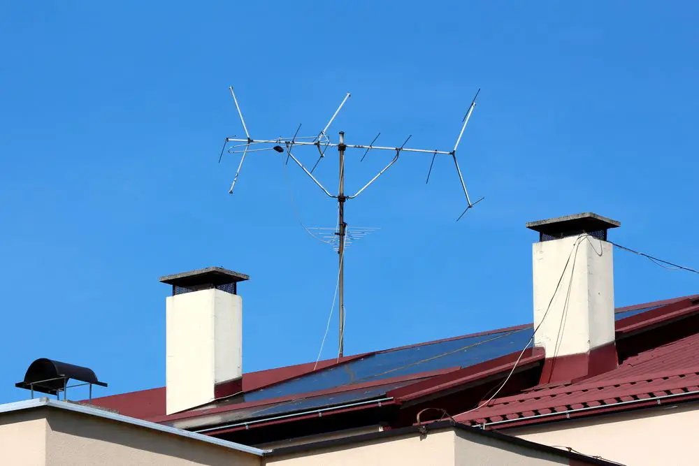 antenna atop steel pole between two chimneys