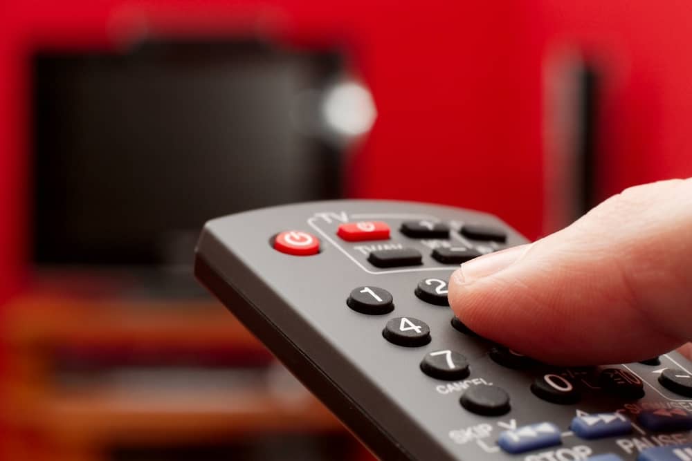 man holding remote control in front of tv